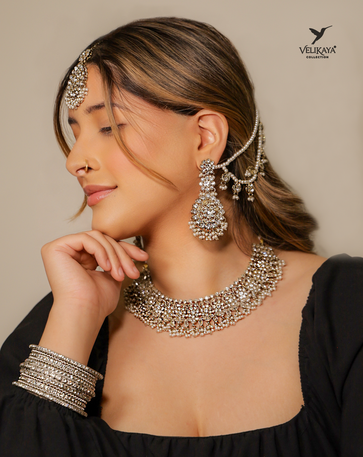Bride wearing silver jewelry including a necklace, earrings, and headpiece