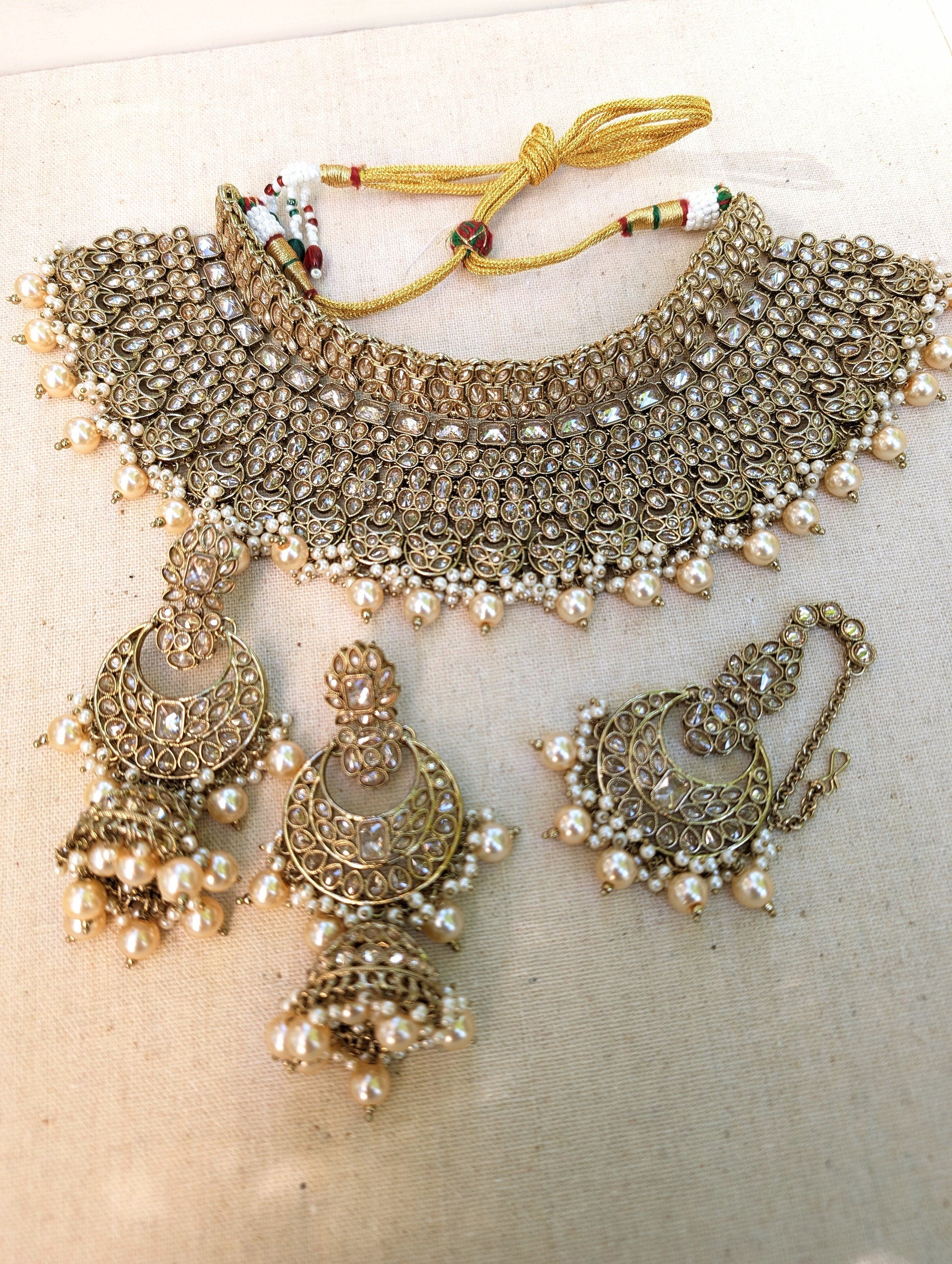 Gold necklace set with chandbali earrings and tikka. Polki choker necklace set. Indian wedding jewelry. Pakistani wedding jewelry. Bollywood necklace set. Punjabi jewelry set. Kundan necklace jhumka. Antique gold-plated necklace. Champagne stones.