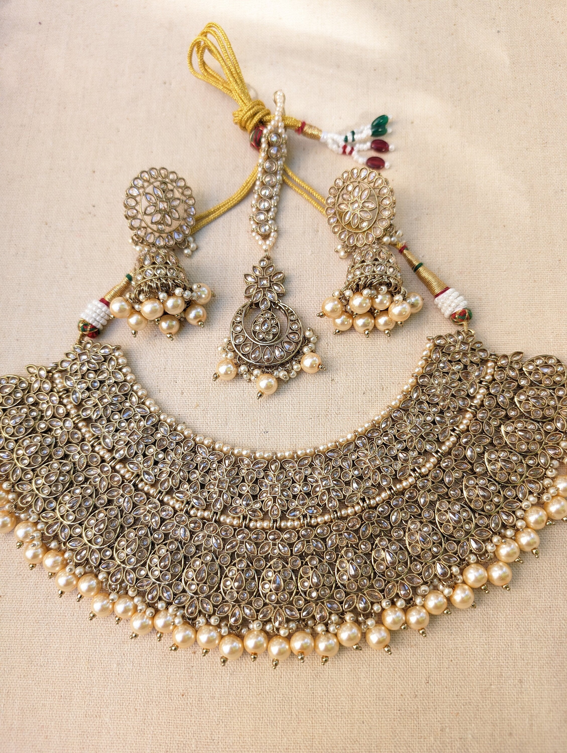 Gold necklace set with chandbali earrings and tikka. Polki choker necklace set. Indian wedding jewelry. Pakistani wedding jewelry. Bollywood necklace set. Punjabi jewelry set. Kundan necklace jhumka. Antique gold-plated necklace. Champagne stones.